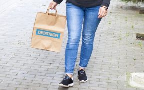 femeie cu punga de hartie Decathlon in mana